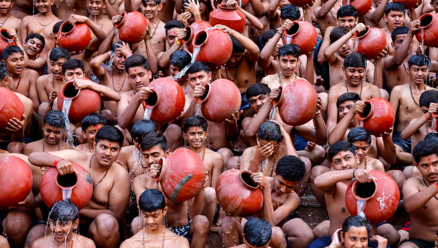 Los estudiantes se vierten agua unos a otros mientras toman un baño sagrado durante una ceremonia organizada para parecerse al festival religioso hindú anual de un mes de duración de Magh Mela, que se celebra durante el mes hindú de Magh, en Ahmedabad, India. REUTERS/Amit Dave