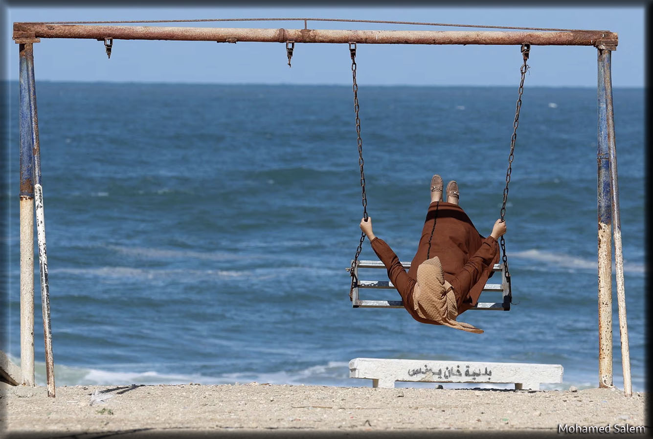 Una mujer palestina desplazada juega en un columpio en la playa, en medio del conflicto en curso entre Israel y el grupo islamista palestino Hamas, en Rafah, en el sur de la Franja de Gaza. REUTERS/Mohamed Salem