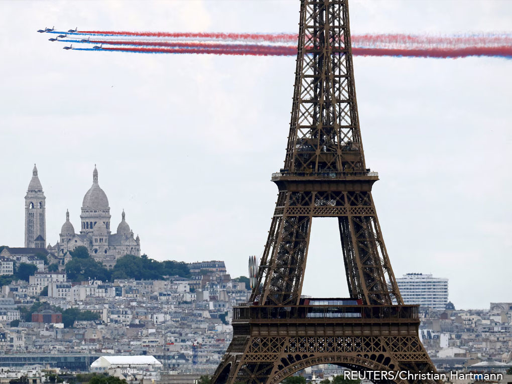 Aviones de combate de la Fuerza Aérea francesa sobrevuelan París, pasando por la Torre Eiffel con la Basílica del Sacré-Coeur de fondo, durante el desfile militar anual del Día de la Bastilla.