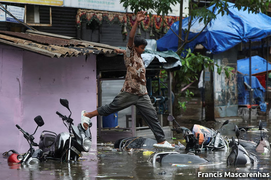 Un niño camina en bicicletas sumergidas por una calle inundada tras las fuertes lluvias en Mumbai, India. REUTERS