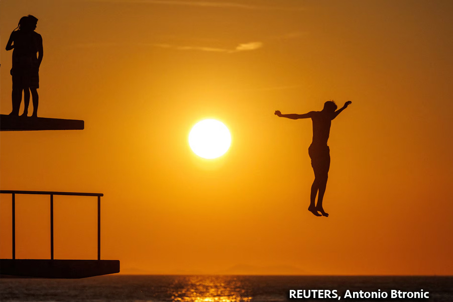 Un hombre salta al mar Adriático durante el calor en Zadar, Croacia.